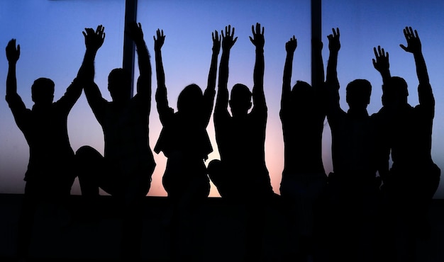 Group of positive young people sitting on a windowsill photo with text space