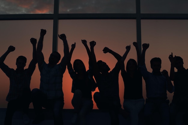 Group of positive young people sitting on a windowsill photo with text space