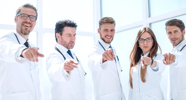 Group of practicing doctors pointing their finger at you