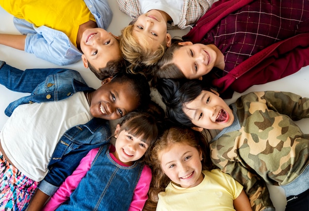 A group of primary schoolers lying on the ground and smiling 