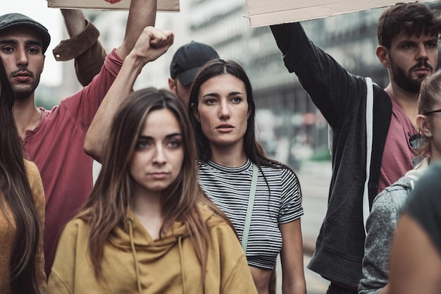 Группа протестующих с их знаками, поднятыми в воздухе, активисты протестуют на улице