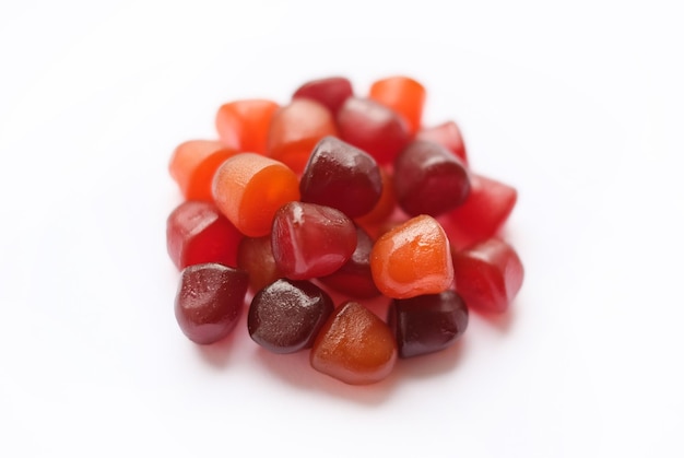 Group of red orange and purple multivitamin gummies isolated on white background