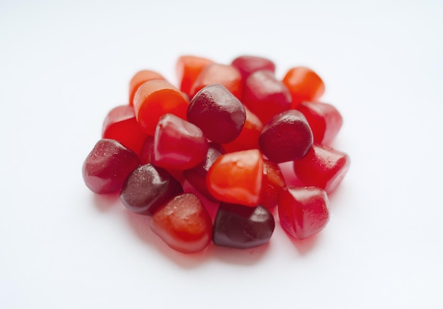 Group of red orange and purple multivitamin gummies isolated on white background