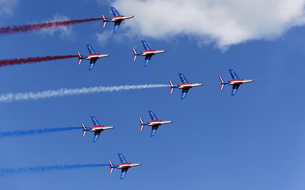 Photo a group of red white and blue airplanes flying in a blue sky