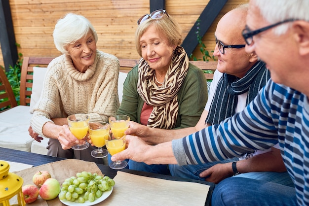 Gruppo di amici pensionati che tostano a pranzo