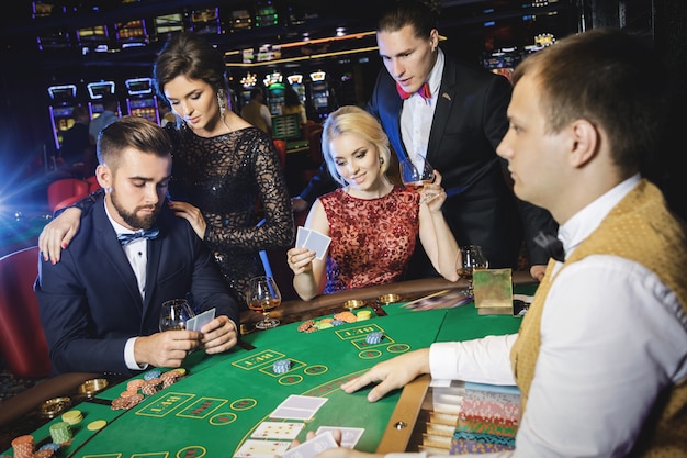 Group of rich people is playing poker in the casino