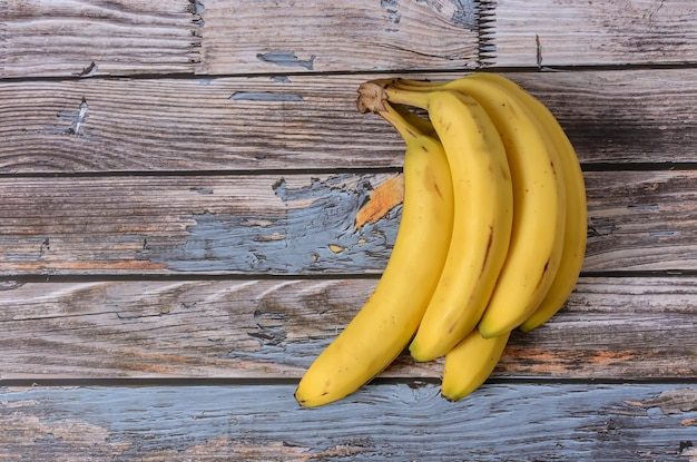 Group of ripe bananas on a wooden background