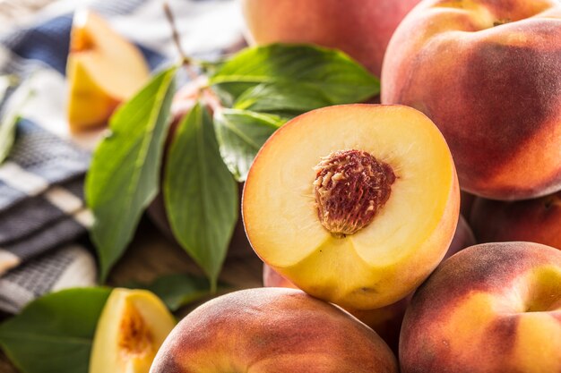 A group a ripe peaches on wooden table.