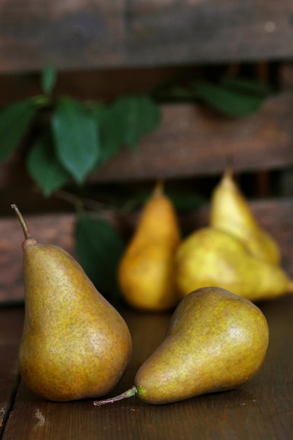 Group of ripe pears lie on old planed wooden boards