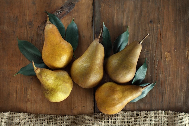 A group of ripe pears lie on old wooden boards