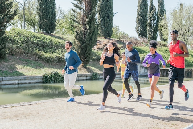 Group of runners training in a park. Happy and smiling.