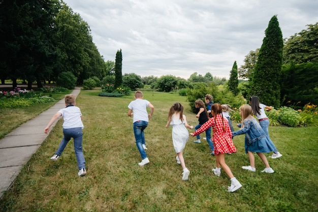 A group of school children runs in the Park in the summer