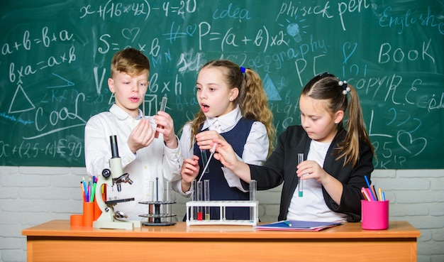 Group school pupils study chemistry in school Boy and girls enjoy chemical experiment Organic chemistry is study of compounds containing carbon Fascinating chemistry Basic chemical reactions