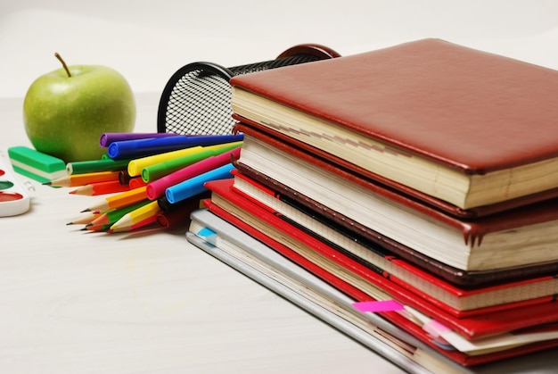 Group of school supplies books diaries on a wooden table surfase closeup photo