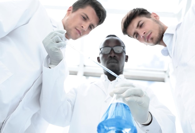Group of scientists examines the liquid in the flask