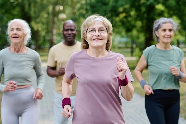 Photo group of senior people running together outdoors in the morning