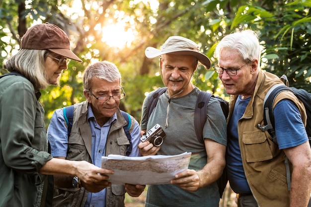 Foto gruppo di escursionisti senior che controllano una mappa per la direzione