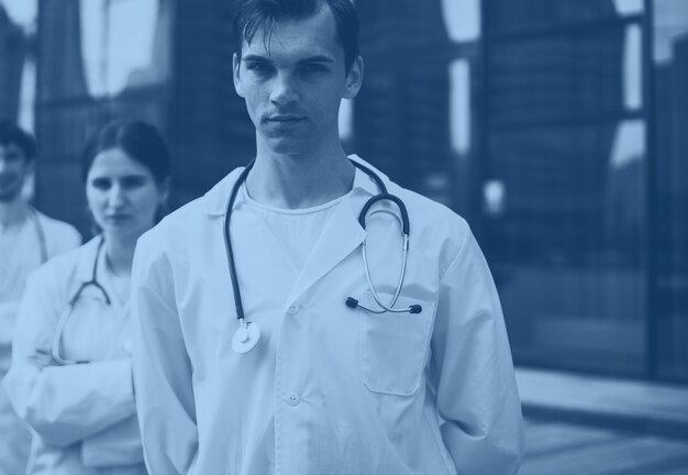 Group of serious young doctors standing outside the hospital