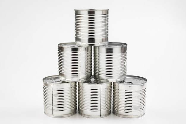 Group of silver canned food on white wall.