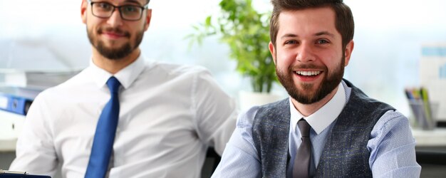 Group of smiling bearded businessmen in suit and tie