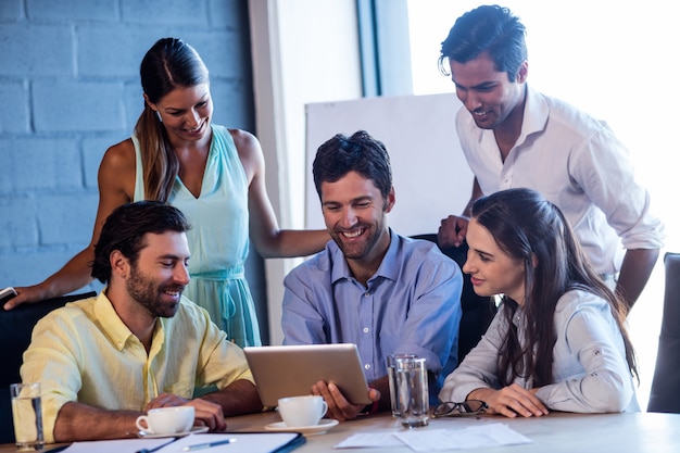 Group of smiling coworkers using a laptop