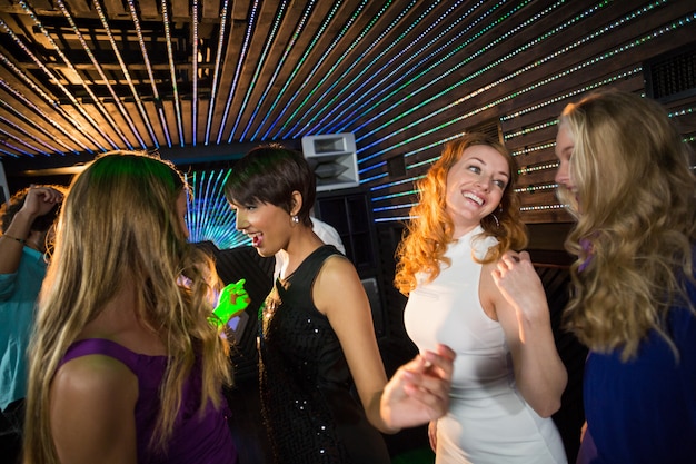 Group of smiling friends dancing on dance floor