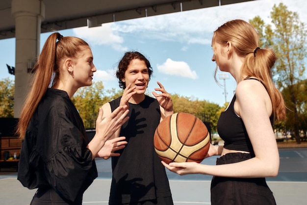 A group of smiling friends have fun discussing and laughing at the city playground the concept of