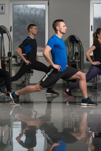 Group Of Smiling People Exercising In The Gym