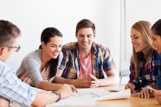 group of smiling students with blueprint