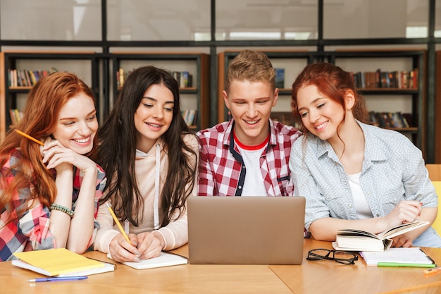 Group of smiling teenagers doing homework