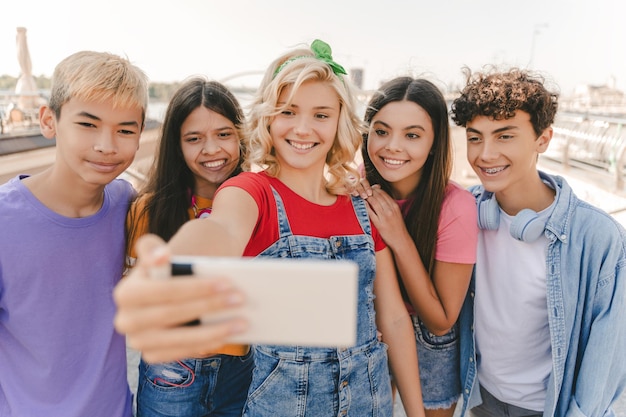 Группа улыбающихся подростков, делающих селфи на улице, счастливый блогер, влиятельный человек, записывающий видео