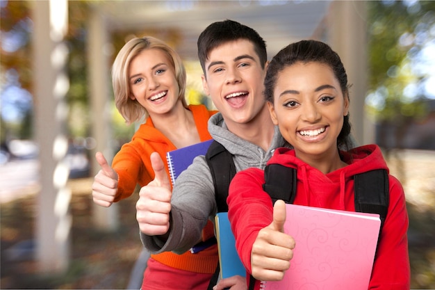 Group of smiling teens showing ok.