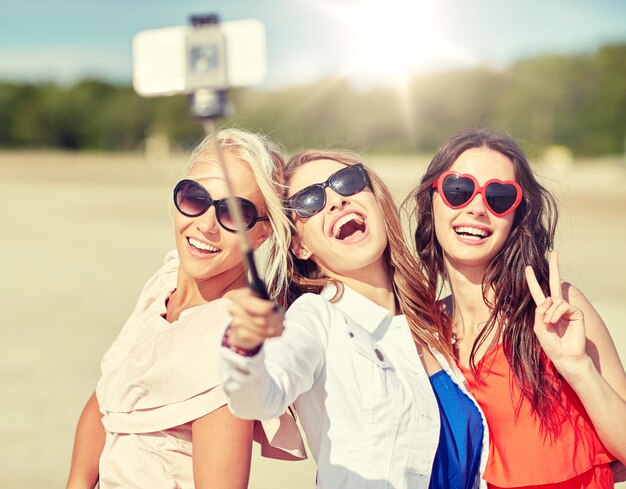 Photo group of smiling women taking selfie on beach