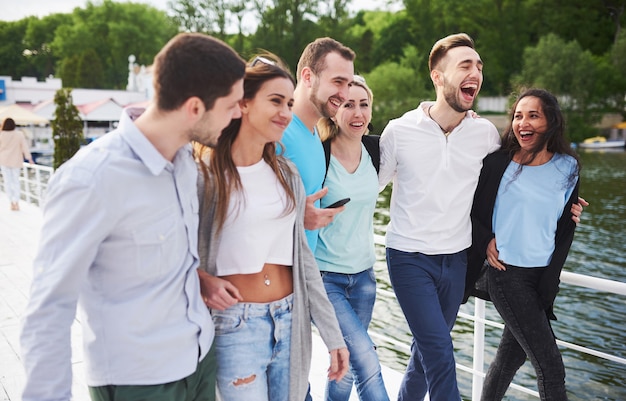 Gruppo di giovani sorridenti e di successo in vacanza sul molo.