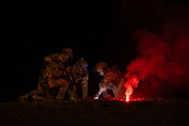 Group of soldiers in camouflage uniforms hold weapons with patrol missions at night