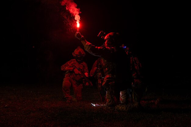 Group of soldiers in camouflage uniforms hold weapons with patrol missions at night