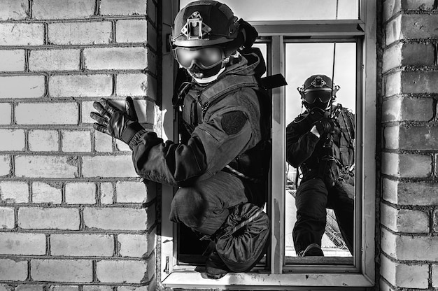 Group of special forces fighters storm the building through the window