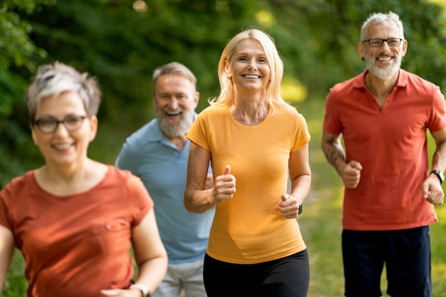 Group of sporty mature people jogging at park together