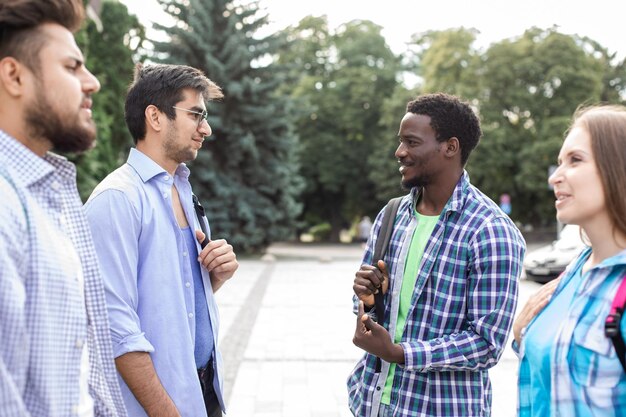 Group of studens stand at the campus and discuss lessons