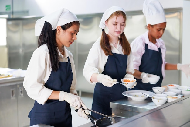 Group of student girl learning Cooking class culinary classroom group of happy young woman multi ethnic students are focusing on cooking lessons in a cooking school