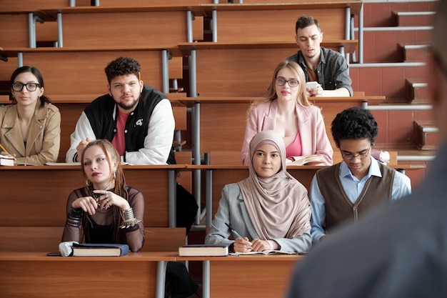 Group of students listening to their teacher at lesson