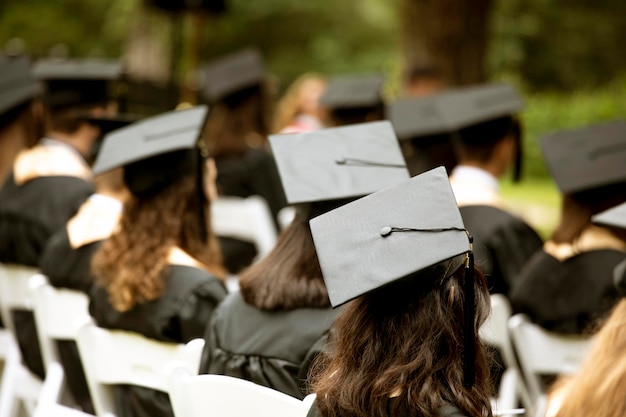 Foto un gruppo di studenti si siede a una cerimonia di laurea incentrata sul cappello sparviere