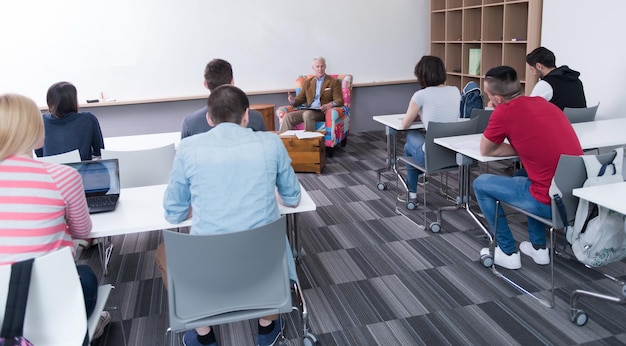 Group of students study with professor in modern school\
classroom