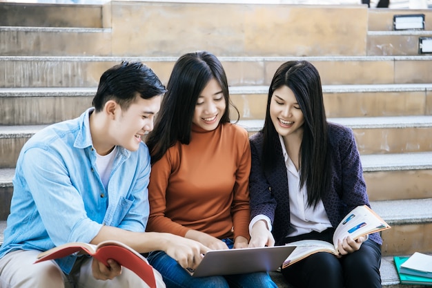 Group students studying researching on laptop Together sitting at college.