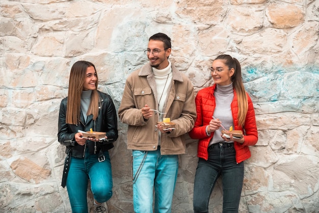 Un gruppo di studenti si prende una pausa dal college per riposarsi, parlare e mangiare dolci deliziosi. focus selettivo