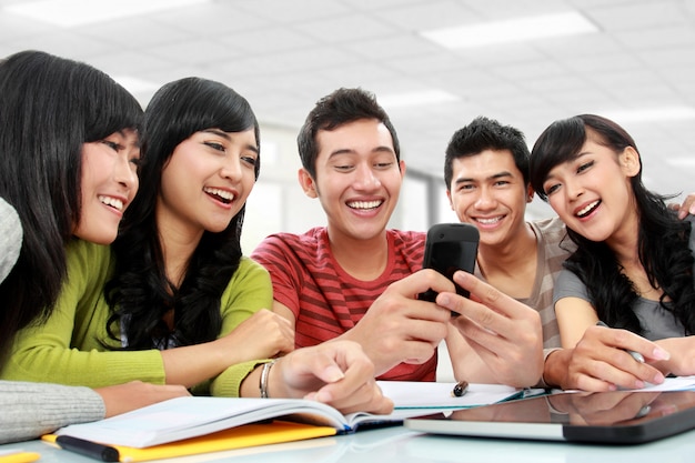 Группа студентов с помощью мобильного телефона