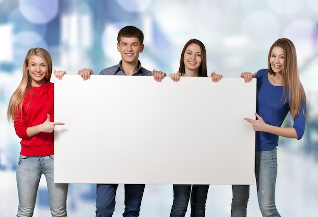 Group of students with blank sign isolated over a white background