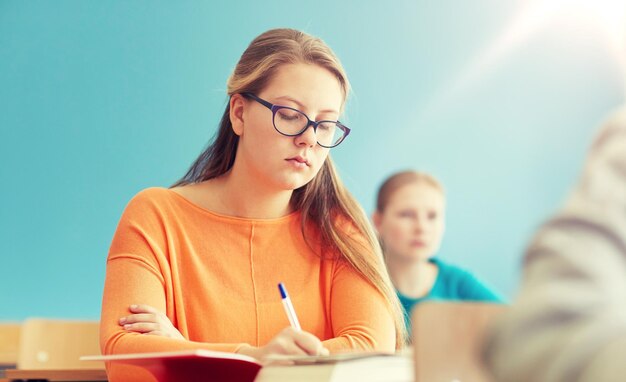 Foto gruppo di studenti con libri che scrivono test scolastici