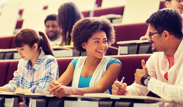 Photo group of students with notebooks in lecture hall