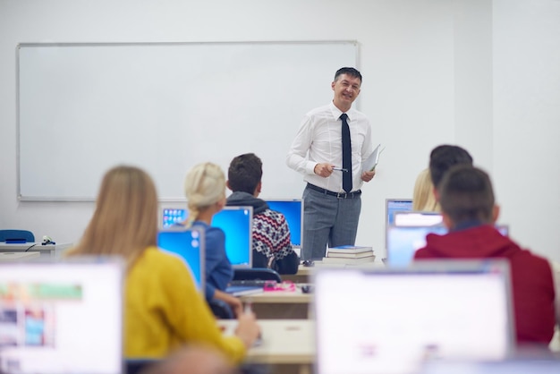 コンピューターラボのクラスで教える学生のグループ学習レッスンで助けとサポートを受けます